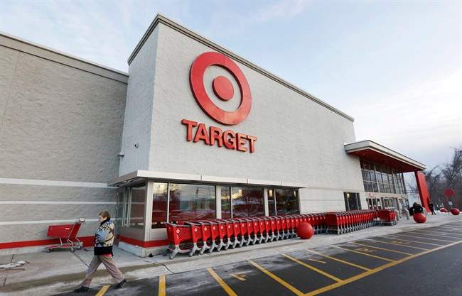 FILE - In this Dec. 19, 2013, file photo, a passer-by walks near an entrance to a Target retail store in Watertown, Mass.