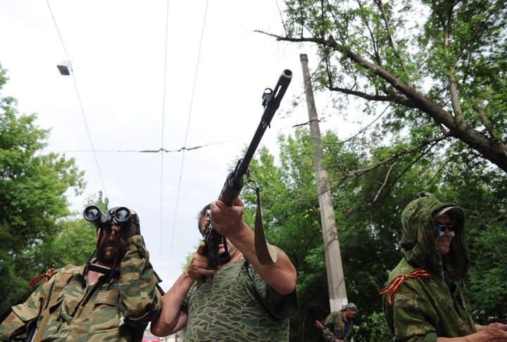 Pro-Russian armed militants stand guard at a barricade which faces a position manned by Ukrainian army soldiers, near the eastern Ukrainian city of Slavyansk, Donetsk region, on May 23, 2014.