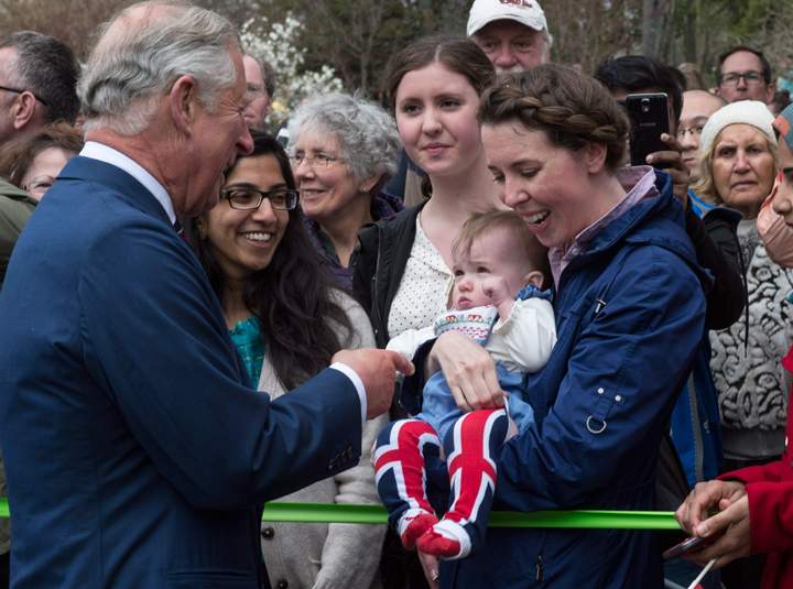 Prince Charles greets a child wearing socks to the Union Jack while touring a park Monday, May 19, 2014 in Halifax. The Royal couple are on a four-day tour of Canada.