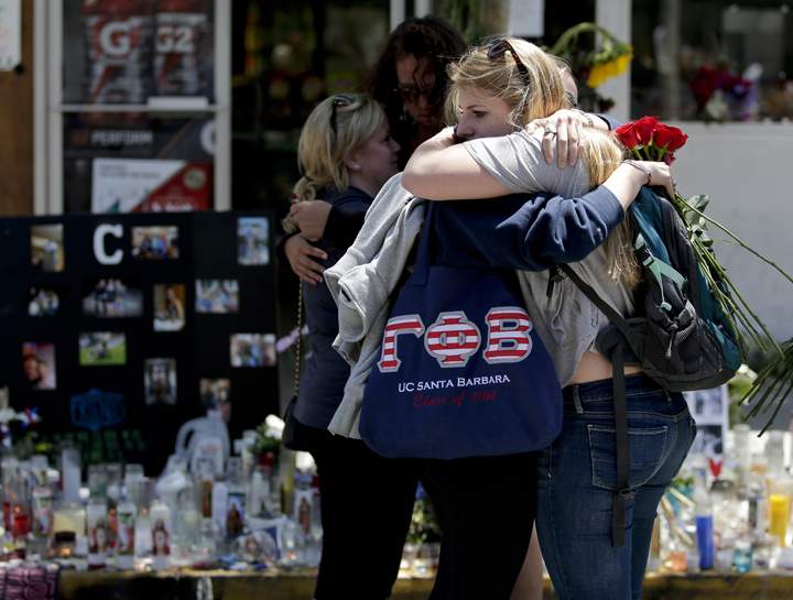Mourners hug in front of the IV Deli Mart, where part of Friday night’s mass shooting took place, on Tuesday, May 27, 2014 in the Isla Vista area near Goleta, Calif. AP Photo/Chris Carlson