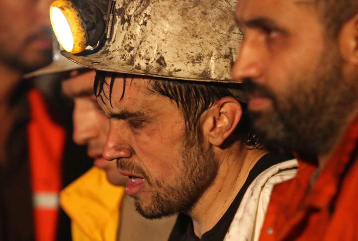 A miner being helped by rescue workers.
