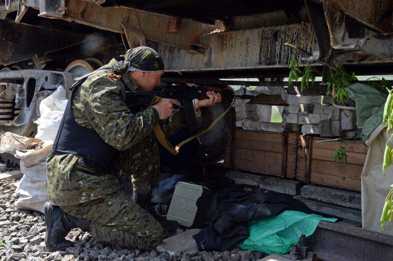 An armed pro-Russian fighter takes position at a checkpoint near the eastern Ukranian city of Slavyansk on May 10, 2014. Tensions were running at fever pitch in eastern Ukraine Saturday on the eve of an independence referendum, as rebels briefly held several Red Cross staff on suspicion of espionage. AFP PHOTO / VASILY MAXIMOV.