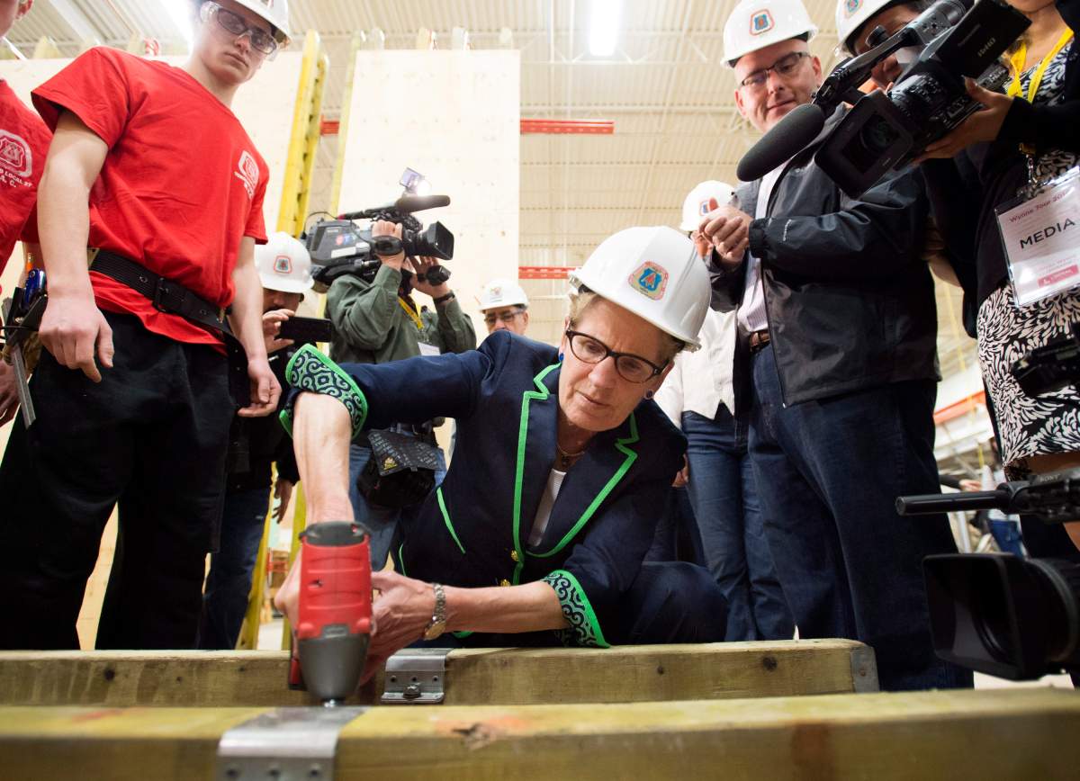 Ontario Liberal Leader Kathleen Wynne practices using a drill during a campaign stop at the Carpenters' Union Local 27 Training Centre in Vaughan, Ont. on Monday, May 12, 2014.