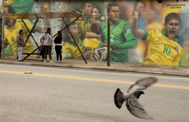 A mural of Brazilian soccer player Neymar, right, and others cover a wall by a bus stop in Sao Paulo, Brazil, Monday, May 26, 2014. The mural was painted by Brazilian street artist Rodolfo Turini ahead of the World Cup soccer tournament that starts in June. (AP Photo/Andre Penner)