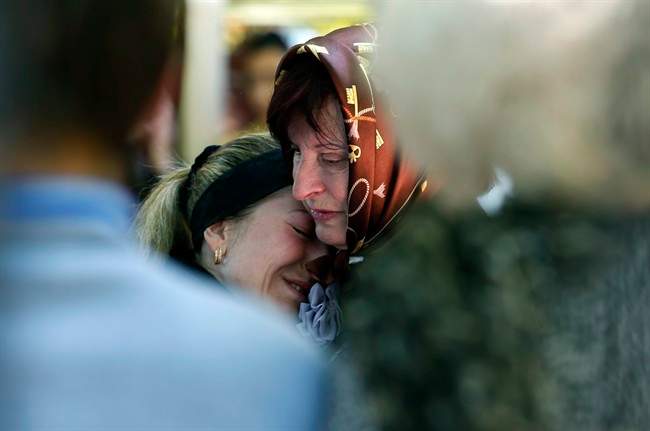 Relatives mourn in front of the casket of a person killed during clashes between Ukrainian and pro-Russian forces last week, during a commemoration service in the center of Slovyansk, eastern Ukraine, Wednesday, May 7, 2014. 