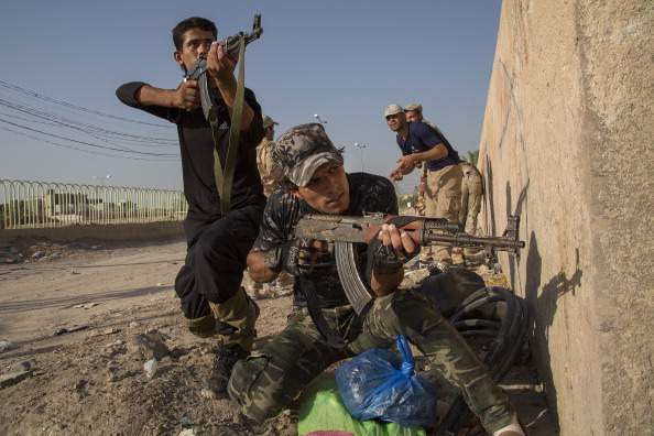 Members of the all volunteer "Iraq of Imam Hussein Regiment" take up positions on a street corner as part of a basic training course June 28, 2014 in the holy Iraqi city of Karbala.