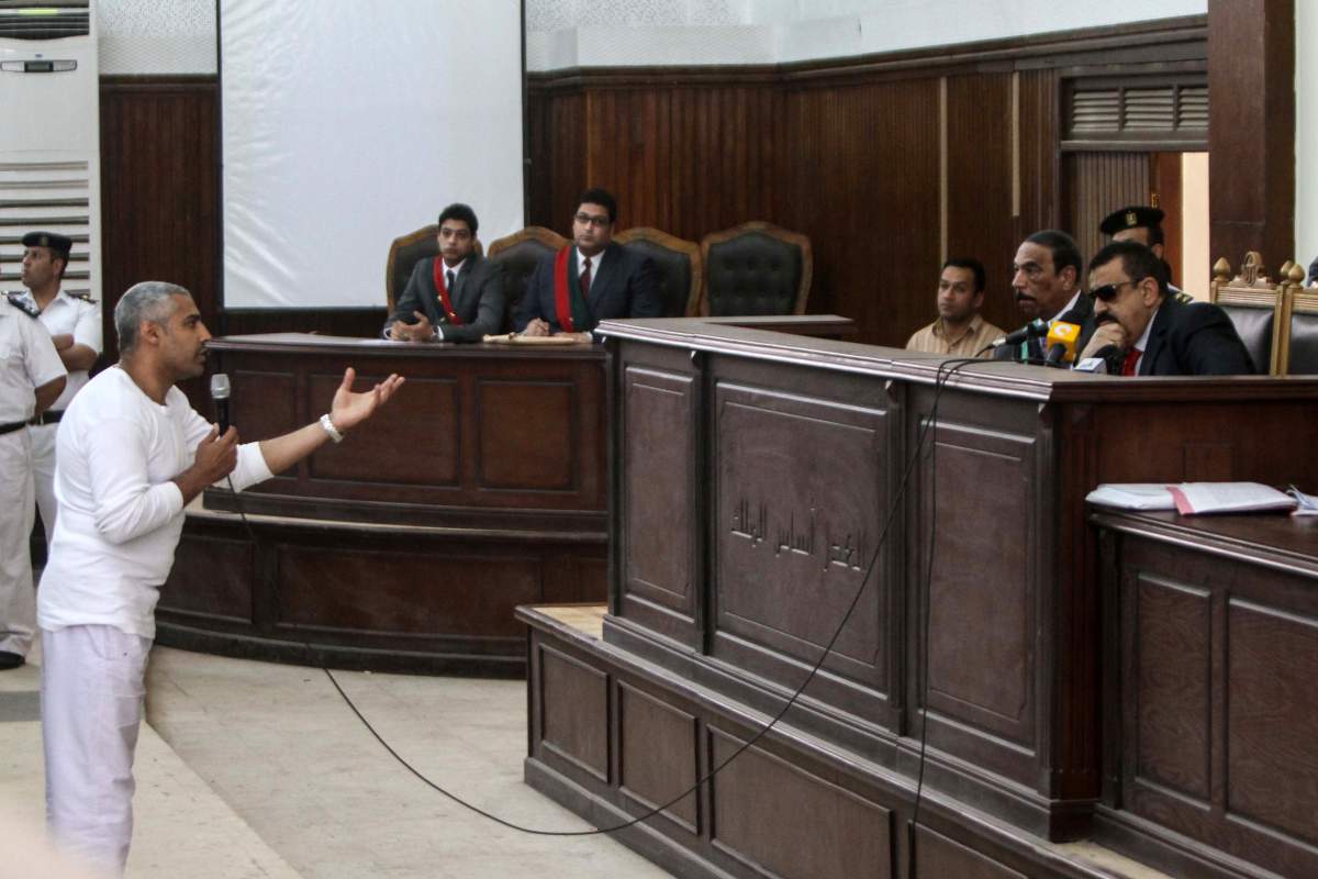 Mohamed Fahmy (L) speaks to Egyptian judge Mohamed Nagy Shehata (R) after being allowed to leave the defendant cage during the trial of 20 individuals, including five Al-Jazeera journalists, for allegedly defaming the country and ties to the blacklisted Muslim Brotherhood on May 3, 2014 .