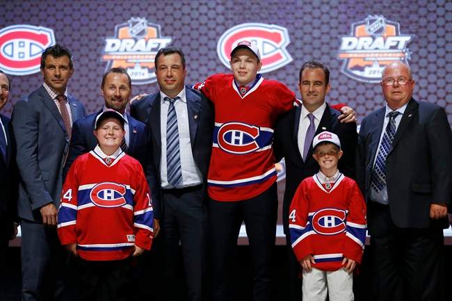 Nikita Scherbak stands with Montreal Canadiens officials after being chosen 26th overall during the first round of the NHL hockey draft, Friday, June 27, 2014, in Philadelphia. (AP Photo/Matt Slocum).