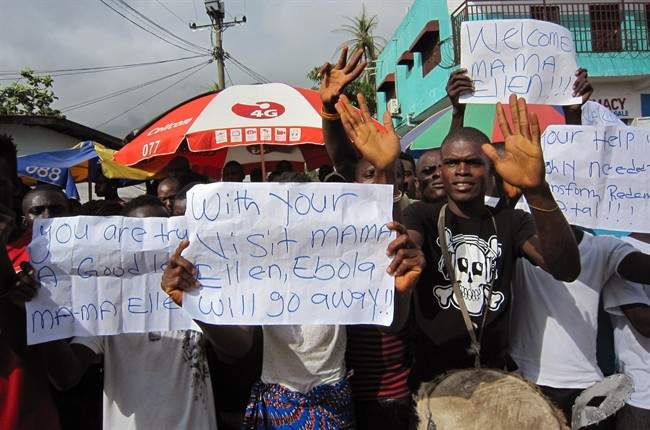 People protest outside a hospital as Liberia President Ellen Johnson Sirleaf visits the area after Ebola deaths in Monrovia, Liberia, Tuesday, June 17, 2014. 