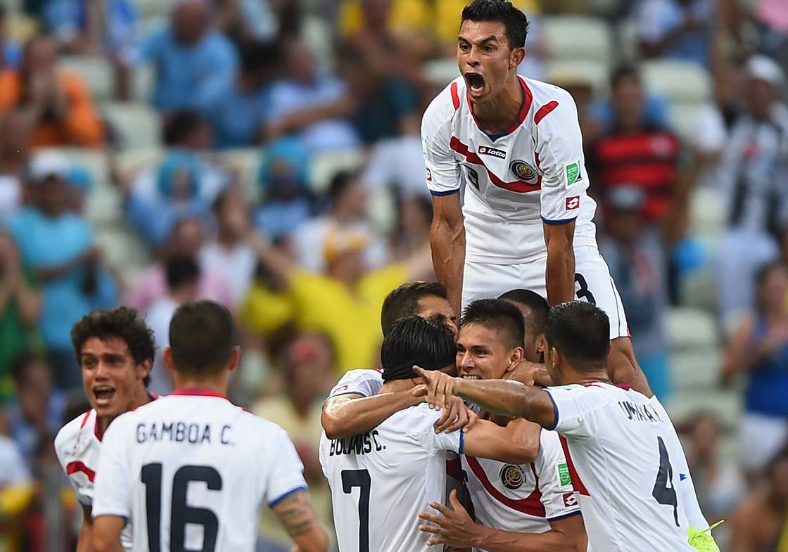 FORTALEZA, BRAZIL - JUNE 14: Giancarlo Gonzalez of Costa Rica jumps on his teammates as they celebrate the team's second goal by Oscar Duarte (C) during the 2014 FIFA World Cup Brazil Group D match between Uruguay and Costa Rica at Castelao on June 14, 2014 in Fortaleza, Brazil. (Photo by Laurence Griffiths/Getty Images)
