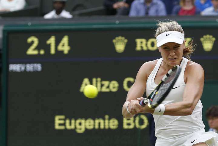 Eugenie Bouchard plays a return to Alize Cornet of France during their women's singles match at the All England Lawn Tennis Championships in Wimbledon, London, Monday, June 30, 2014. 