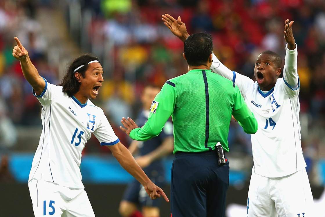 PORTO ALEGRE, BRAZIL - JUNE 15: Roger Espinoza (L) and Oscar Boniek Garcia of Honduras protest France's second goal with referee Sandro Ricci during the 2014 FIFA World Cup Brazil Group E match between France and Honduras at Estadio Beira-Rio on June 15, 2014 in Porto Alegre, Brazil. (Photo by Quinn Rooney/Getty Images)