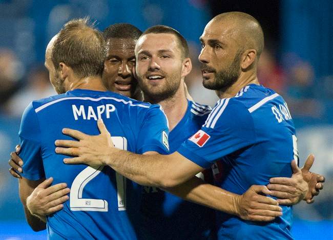 Montreal Impact's Jack McInerney, second right, celebrates with teammates, from left, Justin Mapp, Patrice Bernier and Marco Di Vaio after scoring against the Houston Dynamo.