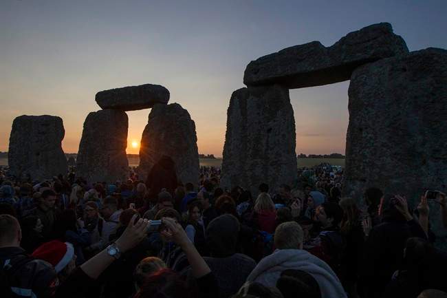 The sun rises as thousands gathered at the ancient stone circle Stonehenge, near Salisbury, England, to celebrate the summer solstice, the longest day of the year, Saturday, June 21, 2014.