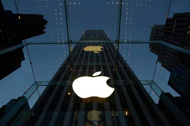 In this Wednesday, Nov. 20, 2013, file photo, the Apple logo is illuminated in the entrance to the Fifth Avenue Apple store, in New York. 