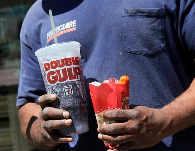 FILE - In this May 31, 2012 file photo, a man leaves a 7-Eleven store with a Double Gulp drink, in New York. The New York Court of Appeals ruled Thursday, June 26, 2014 that the city's health department overstepped its bounds when it restricted the size of sodas. The court is siding with a lower court that overturned the 2012 ban.