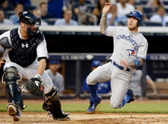 New York Yankees catcher Brian McCann, left, reaches for a wide throw as Toronto Blue Jays Brett Lawrie, right, scores on Colby Rasmus's fourth-inning RBI single in a baseball game at Yankee Stadium in New York, Wednesday, June 18, 2014.