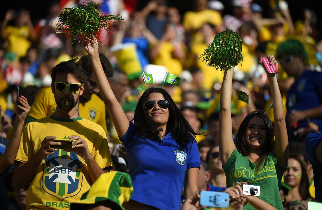Brazilian fans cheer prior to the Group A football match between Brazil and Croatia at the Corinthians Arena in Sao Paulo during the 2014 FIFA World Cup on June 12, 2014. AFP PHOTO / FABRICE COFFRINI (Photo credit should read FABRICE COFFRINI/AFP/Getty Images)