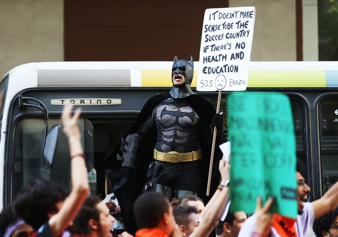 RIO DE JANEIRO, BRAZIL - JUNE 12: A person in a Batman costume holds a sign during an anti-World Cup demonstration on June 12, 2014 in Rio de Janeiro, Brazil. This is the first day of World Cup play. (Photo by Joe Raedle/Getty Images)