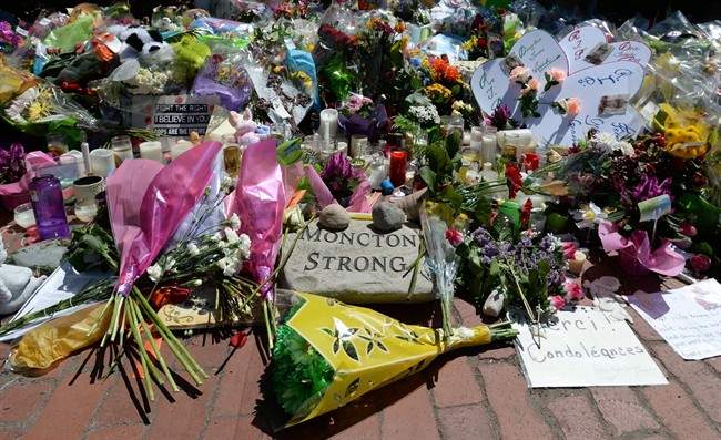 The memorial at the Codiac RCMP detachment in Moncton, N.B. is shown on Sunday, June 8, 2014., continues to grow. Hundreds of people running for three fallen Mounties put their race on hold on Sunday to shake the hands of officers as a memorial in front of an RCMP detachment was dismantled. THE CANADIAN PRESS/Sean Kilpatrick.