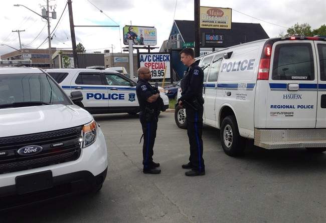 Police officers talk during an investigation into a report of a gunman in Halifax on Saturday, June 7, 2014. THE CANADIAN PRESS/Darren Pittman