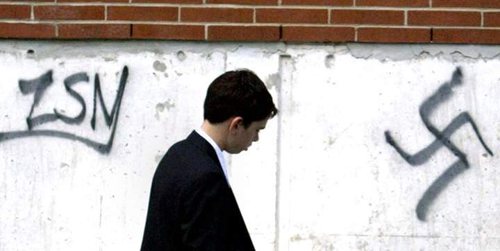 In this FILE photo, Joel Hameiri, 13, walks past graffiti on the Beth Shalom Synagogue after celebrating his Barmitzvah on Sunday June 20, 2004 in Ottawa. Police sent in their hate crimes unit to investigate. 