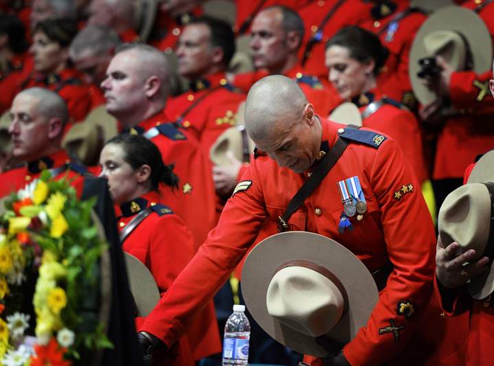 RCMP officers react as they attend the regimental funeral of three slain officers at the Moncton Coliseum in Moncton, N.B. on Tuesday, June 10, 2014. Const. David Ross, Const. Fabrice Georges Gevaudan and Const. Douglas James Larche were killed in a shooting spree last Wednesday.