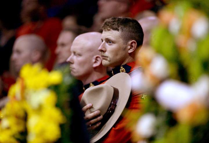 An RCMP officer holds his Stetson close to his heart at the start of the RCMP regimental funeral on Tuesday, June 10, 2014 for the three RCMP officers who were gunned down in Moncton last week.