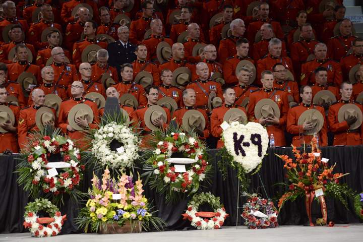 RCMP officers hold their Stetsons to their chests at the start of the RCMP regimental funeral on Tuesday, June 10, 2014 for the three RCMP officers who were gunned down in Moncton last week.