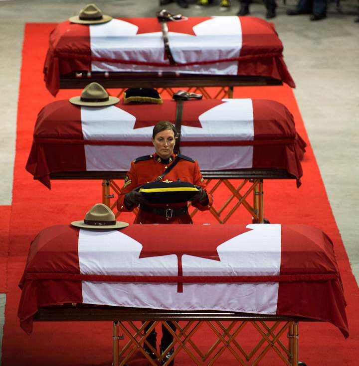 The caskets of the three RCMP officers who were killed in the line of duty are seen at their regimental funeral at the Moncton Coliseum in Moncton, N.B. on Tuesday, June 10, 2014. Const. David Ross, Const. Fabrice Georges Gevaudan and Const. Douglas James Larche were killed in a shooting spree last Wednesday.