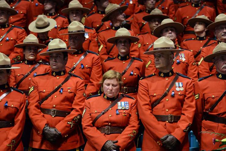 RCMP wait for the start of the regimental funeral for Const. Dave Joseph Ross, Douglas James Larche, and Fabrice Georges Gevaudan at the Moncton Coliseum