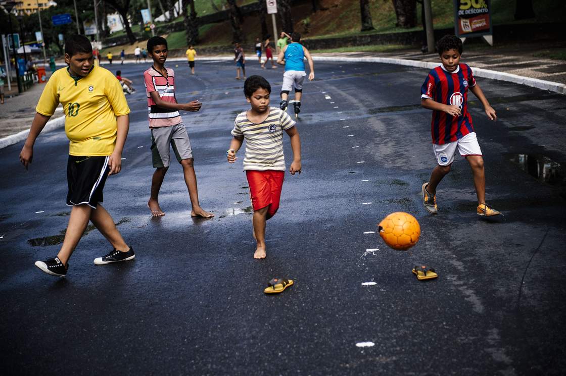 Brazilian children play football on a street near the Fonte Nova Arena stadium in Salvador on June 8, 2014, ahead of the 2014 FIFA World Cup in Brazil. AFP PHOTO / DIMITAR DILKOFF (Photo credit should read DIMITAR DILKOFF/AFP/Getty Images)