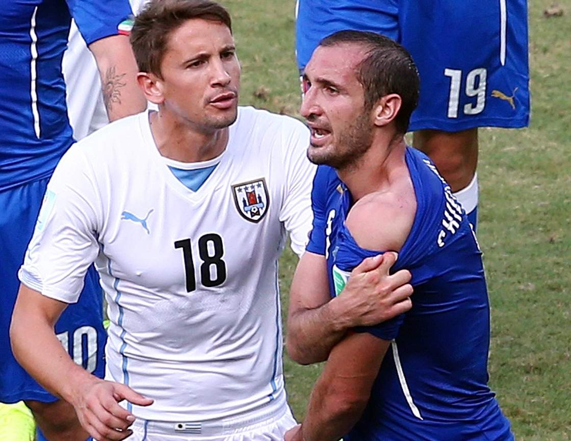NATAL, BRAZIL - JUNE 24: Giorgio Chiellini of Italy pulls down his shirt after a clash with Luis Suarez of Uruguay (not pictured) as Gaston Ramirez of Uruguay looks on during the 2014 FIFA World Cup Brazil Group D match between Italy and Uruguay at Estadio das Dunas on June 24, 2014 in Natal, Brazil. (Photo by Julian Finney/Getty Images)
