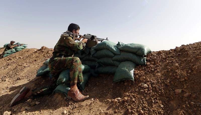 Members of Kurdish Peshmerga forces hold their position on June 21, 2014, in the Iraqi village of Basheer, 15 kilometers south of the city of Kirkuk, overlooking locations under Sunni militants led by the Islamic State of Iraq and the Levant (ISIL). Sunni militants led by the Islamic State of Iraq and the Levant took control of an Iraq-Syria border crossing after Syrian rebels withdrew overnight, security officers and witnesses said. AFP PHOTO/KARIM SAHIB.