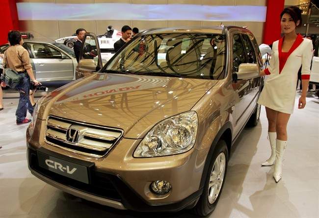 In this April 21, 2005 file photo, a model poses by a Honda\’s CR-V at Auto Shanghai 2005 exhibition in Shanghai, China.