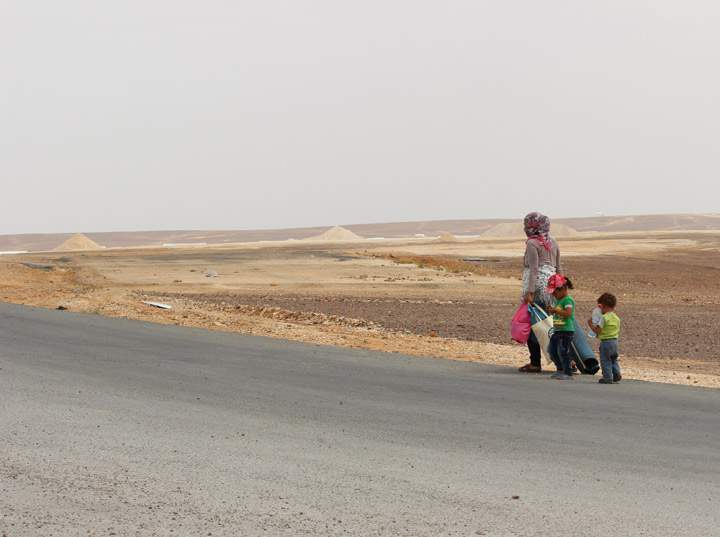 A family walks down a road in Azraq Camp
