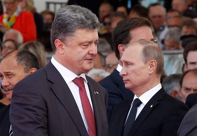 Ukraine's President-elect Petro Poroshenko, left, walks past Russian President Vladimir Putin during the commemoration of the 70th anniversary of the D-Day in Ouistreham, western France, Friday, June 6, 2014. (AP Photo/Christophe Ena, Pool).