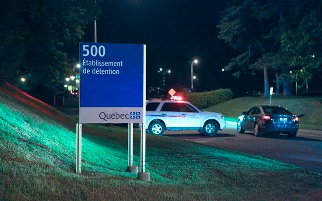 Police cars are shown in front of the Orsainville Detention Centre near Quebec City on Saturday June 7, 2014. There has been another jailbreak in Quebec involving a helicopter. Quebec Provincial Police say three inmates have escaped from the Orsainville Detention Centre. 