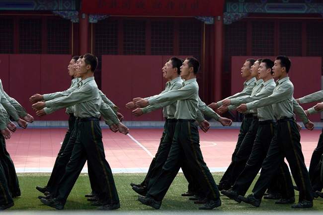 Chinese paramilitary policemen chant slogans as they march at a barrack near Tiananmen Gate in Beijing Wednesday, June 4, 2014.