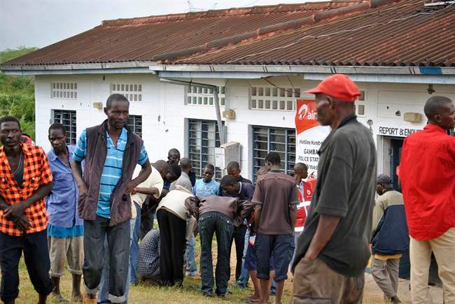 People watch the site where gunmen attacked outside the Gamba police station in Gamba, Kenya, Sunday, July 6, 2014. Eighteen people were killed in overnight attacks by the gunmen in two counties on the Kenyan coast, where last month al-Qaida-linked militants claimed responsibility for killing 65 people, the Kenya Red Cross said Sunday. (AP Photo).