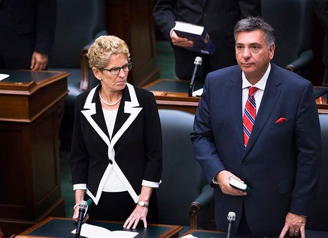 Ontario Premier Kathleen Wynne is sworn in alongside Liberal MPP Charles Sousa during a swearing in ceremony at Queen's Park in Toronto on Wednesday, July 2, 2014. 