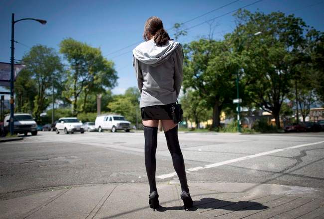 A sex trade worker is pictured in downtown Vancouver, B.C., Wednesday, June, 3, 2014. A Toronto newspaper says it will defy the ban on sex ads that goes into effect on Dec. 6, 2014.