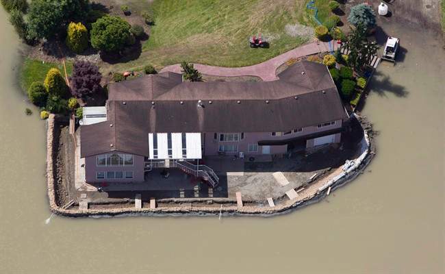 A sandbag dike holds back the water from the Fraser River in Chilliwack, B.C., on June 28, 2012. A streamflow advisory has been issued for the Fraser River.