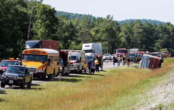Investigators look over the scene of a bus accident on Interstate 87, also known as the Adirondack Northway, in North Hudson, N.Y. on Friday July 18, 2014.