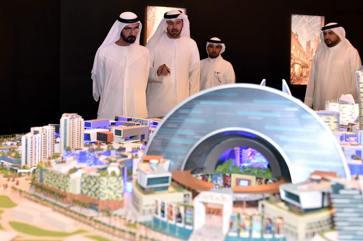 In this Saturday July 5, 2014 photo released by the Dubai Government Media Office, UAE Prime Minister and Dubai ruler Sheik Mohammed bin Rashid Al Maktoum, left, listens to Mohammed Abdullah Al Gergawi, center, Chairman of Dubai Holding during the presentation of a sprawling real-estate project known as the Mall of the World that is planned to include an 8 million square foot (743,224 square meter) mall, a climate-controlled street network, a theme park covered during the scorching summer months and 100 hotels and serviced apartments. 