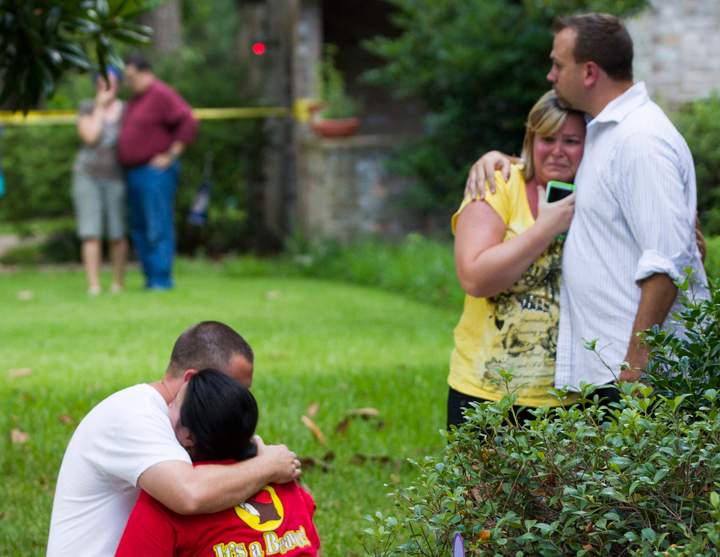 Neighbors embrace each other following a shooting Wednesday, July 9, 2014, in Spring, Texas. Deputies have cornered a man suspected in a shooting at a suburban Houston home that resulted in multiple fatalities.