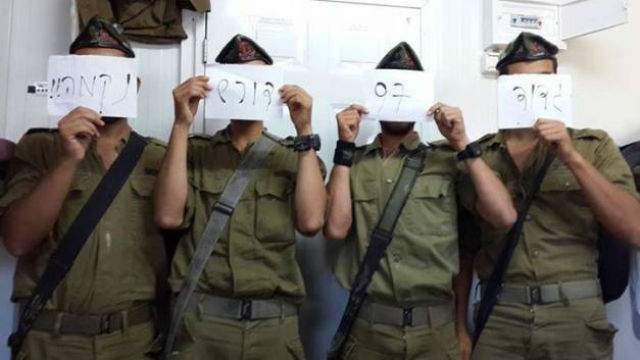 Members of the Israeli Defense Force hold signs bearing the message “Battalion 97 demands revenge” in a photo that was posted to a Facebook group calling for revenge for the murders of three Israeli teens.