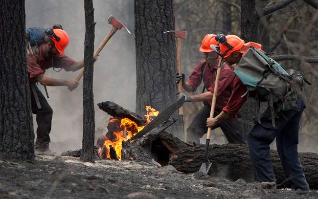 Firefighters tackle a flare up at the Smith Creek fire located on a hillside in West Kelowna, B.C., Saturday, during wildfire season.