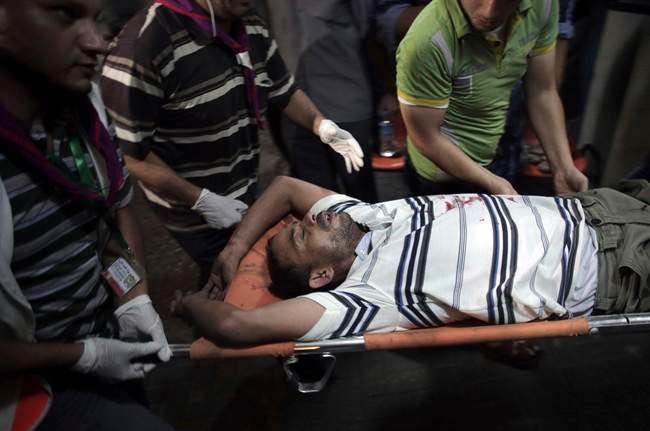 A wounded Palestinian is carried into Shifa hospital in Gaza City, northern Gaza Strip, early Friday, July 18, 2014. The heavy thud of tank shells, often just seconds apart, echoed across the Gaza Strip early Friday as thousands of Israeli soldiers launched a ground invasion, escalating a 10-day campaign of heavy air bombardments to try to destroy Hamas' rocket-firing abilities and the tunnels militants use to infiltrate Israel. (AP Photo/Khalil Hamra).