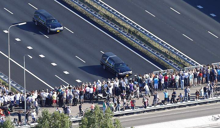 This aerial photo shows people watching from a bridge a convoy of hearses carrying coffins containing the remains of victims of the downed Malaysia Airlines flight MH17, driving from the Eindhoven Airbase to Hilversum on July 23, 2014.
